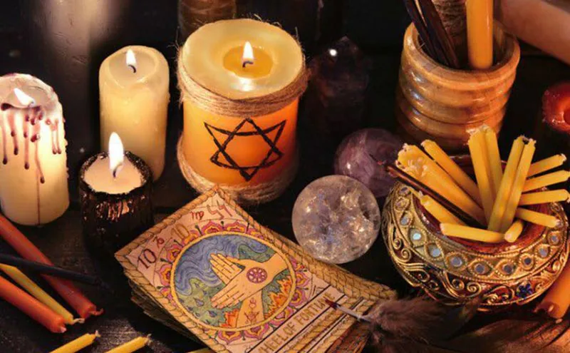 Predicciones certeras: altar con velas encendidas, amatista y cartas ilustradas