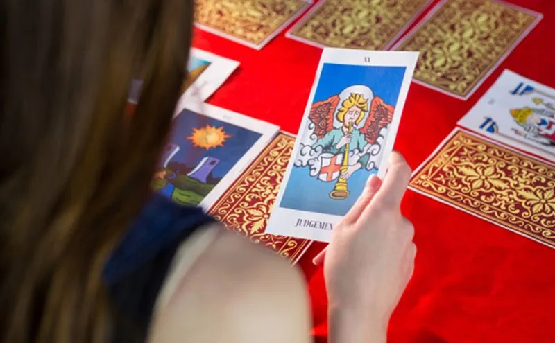 Tarot 806 económico: cartas doradas sobre mantel rojo