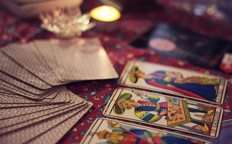 Tarot confidencial: cartas en abanico sobre mantel granate
