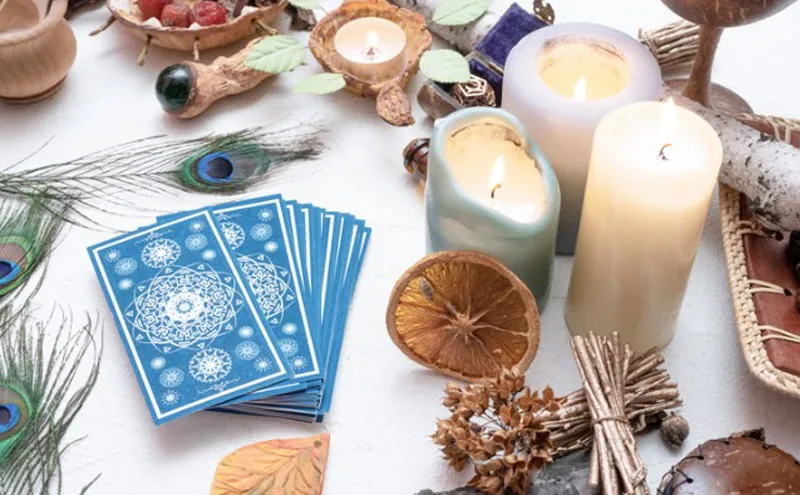 Tarot económico: cartas azules sobre mesa blanca con velas