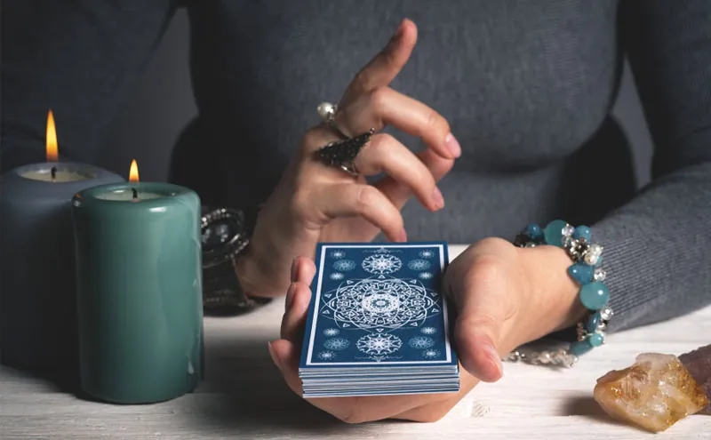 Tarot honesto: mazo azul entre dos velas verdes
