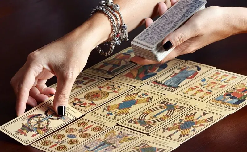 Vidente de nacimiento colocando las cartas del tarot sobre la mesa